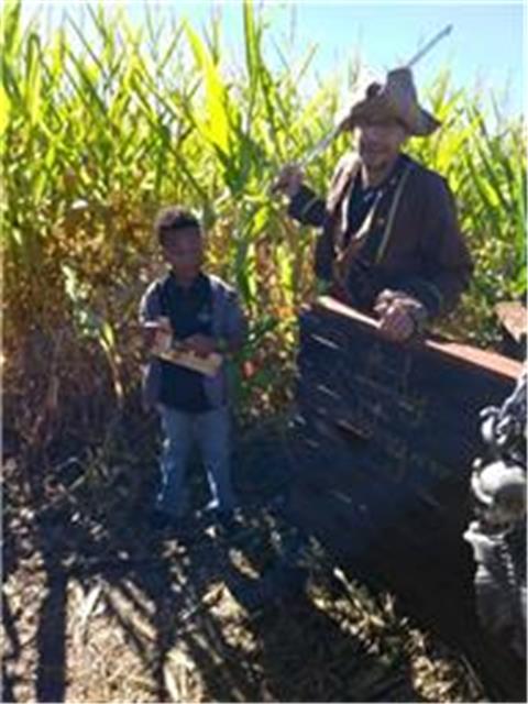 Child and man dressed in costume in the corn maze